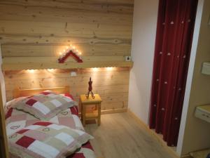 - une chambre avec 2 lits et un mur en bois dans l'établissement Appartement Châtel, 3 pièces, 4 personnes - FR-1-198-172, à Châtel