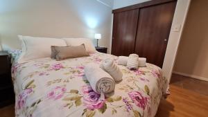 1 dormitorio con 1 cama con toallas en La Donna muy cerca del centro en San Carlos de Bariloche