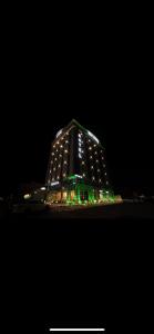 um edifício iluminado à noite com luzes verdes em Five Season Hotel em Al Khobar
