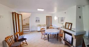 ein Wohnzimmer mit einem Tisch, Stühlen und einem Kamin in der Unterkunft Locations-06 La Maison Du Paysan in Le Bar-sur-Loup