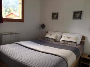 uma cama com duas almofadas num quarto com uma janela em Appartement Valfréjus, 3 pièces, 6 personnes - FR-1-265-165 em Valfréjus