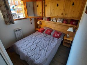 ヴァルフレジュスにあるAppartement Valfréjus, 3 pièces, 6 personnes - FR-1-265-171の小さなベッドルーム(赤い枕のベッド付)