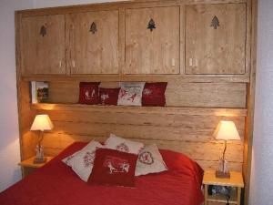 ヴァルフレジュスにあるAppartement Valfréjus, 3 pièces, 6 personnes - FR-1-265-171のベッドルーム1室(木製のヘッドボード、赤いベッド1台付)