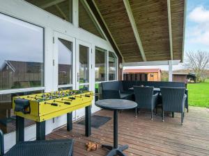 eine abgeschirmte Veranda mit einem Tisch, Stühlen und einem Tischfußball in der Unterkunft 6 person holiday home in Sydals in Vibøge