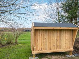 ein Holzhaus mit einem schwarzen Dach auf einem Feld in der Unterkunft 6 person holiday home in Sydals in Vibøge