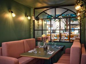 a restaurant with a table and chairs and a window at Royal Madeleine Hotel & Spa in Paris