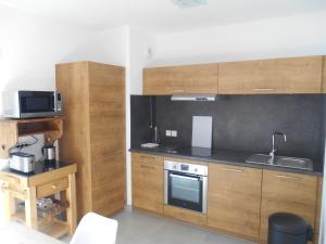 シャテルにあるAppartement spacieux à Châtel – 3 Pièces, 6 Personnes, Balcon Sud, Garage, 3 Étoiles - FR-1-198-184のキッチン(木製キャビネット、シンク、電子レンジ付)