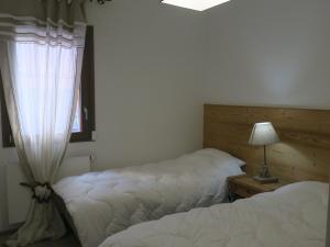 シャテルにあるAppartement spacieux à Châtel – 3 Pièces, 6 Personnes, Balcon Sud, Garage, 3 Étoiles - FR-1-198-184のベッドルーム1室(ベッド2台、窓、ランプ付)