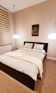 1 dormitorio con 1 cama grande y 2 luces colgantes en Les gîtes de Rozélie, en Gembloux