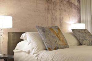 a bed with two pillows on it with two lamps at "A casa di Giacomo" Luxury Rooms con aria condizionata in Bergamo