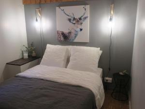 a bedroom with a bed with white sheets and two lights at Appartement Châtel, 2 pièces, 5 personnes - FR-1-198-196 in Châtel