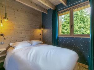 a bedroom with a white bed and a window at Chalet La Clusaz, 5 pièces, 10 personnes - FR-1-437-80 in La Clusaz