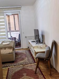 Zimmer mit einem Schreibtisch, einem Stuhl und einem Bett in der Unterkunft LoRed apartment in Sarajevo