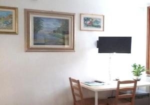 Habitación con mesa, escritorio y TV. en B&b Art Boutique en Mantua