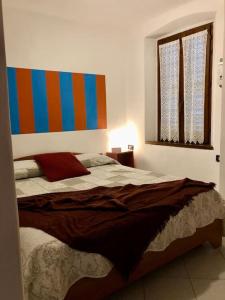 1 dormitorio con 1 cama con cabecero colorido en Casa del borghetto, en Intra
