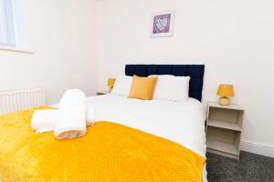 a bedroom with a large bed with a yellow blanket at Albion High Street Apartments in Leeds