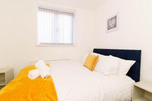 ein Schlafzimmer mit einem Bett mit gelben und weißen Kissen in der Unterkunft Albion High Street Apartments in Leeds