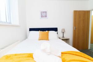 a bedroom with a large white bed with orange pillows at Albion High Street Apartments in Leeds