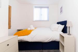 Un dormitorio con una cama azul y blanca y una ventana en Albion High Street Apartments en Leeds