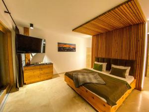 a bedroom with a large bed and a television at Ferienvilla Joachimsberg mit Swimspa, Sauna und Ötscherblick in Wienerbruck
