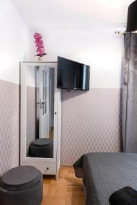 ワルシャワにあるClickTheFlat Constitution Square Apart Roomsの鏡付きのベッドルーム、壁にテレビが備わります。