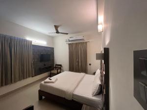 a bedroom with a bed and a ceiling fan at PPH Living Athithi Inn Corporate Stay in Coimbatore