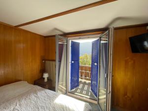 ein Schlafzimmer mit einem Bett und einem großen Fenster in der Unterkunft Schlafen ohne Frühstück Check-in 24-7 & Late Check-in in Ausserberg