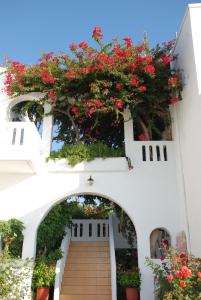 an archway with red flowers on a building at Villas Michalis in Chorafakia