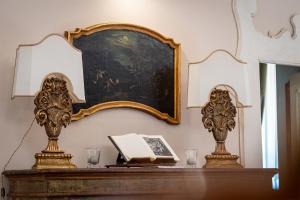 uma mesa com um livro e um espelho na parede em Dimora Villa Ricci em Pedaso