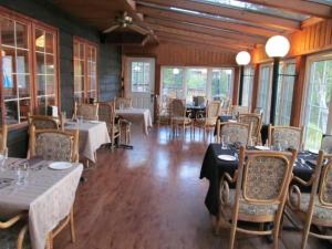 a dining room with tables and chairs and windows at The Grand Tappattoo Resort, an Ascend Collection Resort in Seguin 