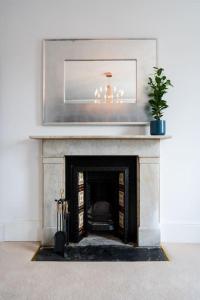 a living room with a fireplace with a potted plant at Luxury Duplex Penthouse on the Beach with Panoramic Sea Views in Herne Bay