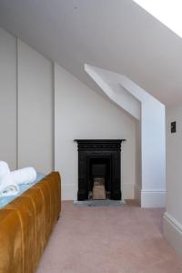 a white room with a fireplace and a couch at Luxury Duplex Penthouse on the Beach with Panoramic Sea Views in Herne Bay