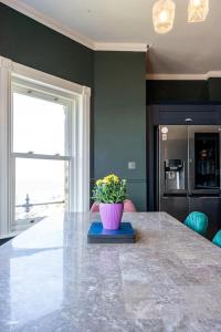 a kitchen with a table with a potted plant on it at Luxury Duplex Penthouse on the Beach with Panoramic Sea Views in Herne Bay