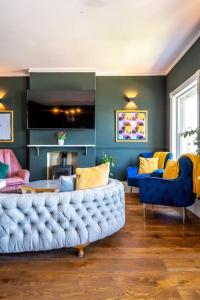 a living room with a blue couch and chairs at Luxury Duplex Penthouse on the Beach with Panoramic Sea Views in Herne Bay