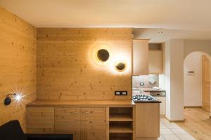 a kitchen with wooden walls and a counter top at Residence Chalet Pinis in Corvara in Badia