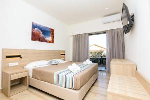 a hotel room with a bed and a balcony at Passas Mare Apartments & Studios in Benitses