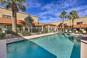 a swimming pool in front of a building with palm trees at Modern Fountain Hills Townhome with Private Patio! in Fountain Hills