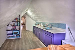 an attic kitchen with purple cabinets and blue tiles at Cozy Portsmouth Studio about 3 Mi to Old Towne in Portsmouth