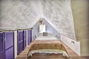 een slaapkamer met een groot bed met paarse luiken bij Cozy Portsmouth Studio about 3 Mi to Old Towne in Portsmouth