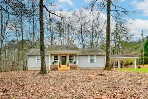 una casa bianca con una porta gialla nel bosco di Beautiful Clarkesville Home about 8 Mi to Helen! a Clarkesville