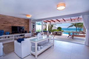 uma sala de estar com vista para o oceano em Casa Margot - Casas de Luxo Pé na Areia em Juqueí