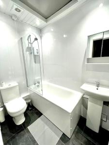 a white bathroom with a toilet and a sink at Loft apartment in Joppa in Edinburgh