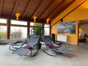 a group of chairs in a room with windows at Vitalhotel Krainz in Loipersdorf bei Fürstenfeld