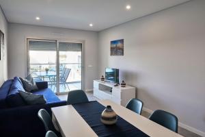 a living room with a blue couch and a table at Nice apartment near the beach - Monte Gordo in Monte Gordo