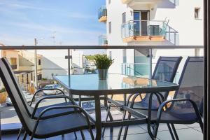 a glass table and chairs on a balcony at Nice apartment near the beach - Monte Gordo in Monte Gordo