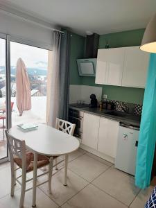 une cuisine avec une table et une table ainsi qu'une fenêtre dans l'établissement chambre 2 vue lac av piscine, à Prunières