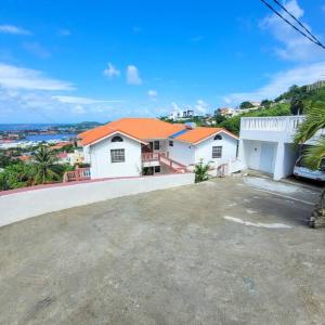 a house with a large driveway in front of it at 1 Bed Apt overlooking Rodney Bay in Gros Islet