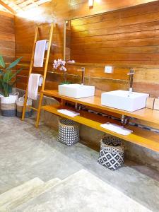 a bathroom with two sinks on a wooden wall at AWERA RESORT in Tua Pejat