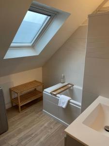 La salle de bains est pourvue d'un lavabo et d'une lucarne. dans l'établissement Cosy's Kerguelen - Longère jardin, à Larmor-Plage