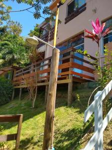a house with a fence and a frisbee at La Casa Rozada Prumirim in Ubatuba